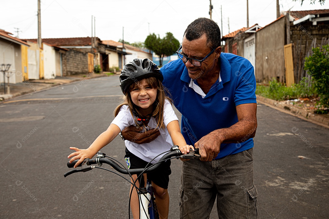 Pai ensinado sua filha a andar de bicicleta