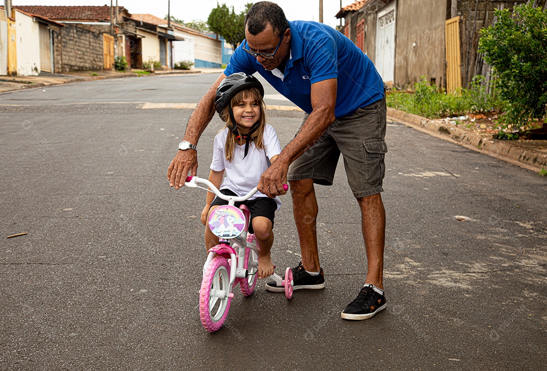 Pai ensinado sua filha a andar de bicicleta