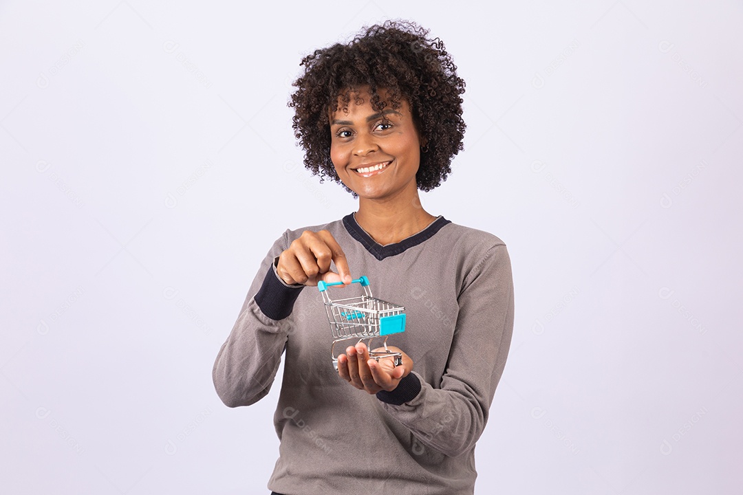 Linda mulher garota jovem cabelo afro segurando carrinho de compras