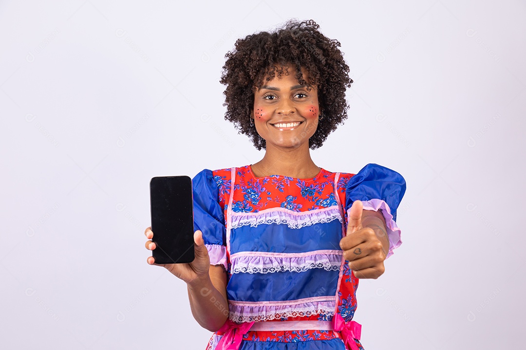 Mulher jovem fantasiada celebrando festas juninas segurando celular smartphone