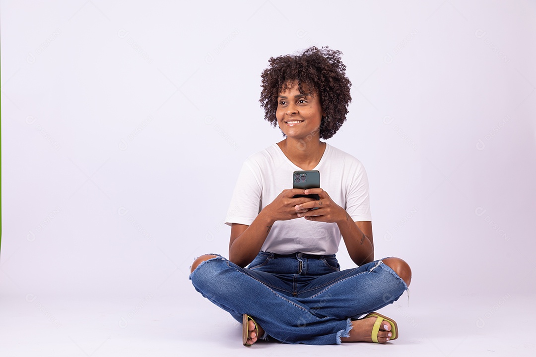 Linda mulher jovem garota com lindo cabelo afro mexendo em seu smartphone