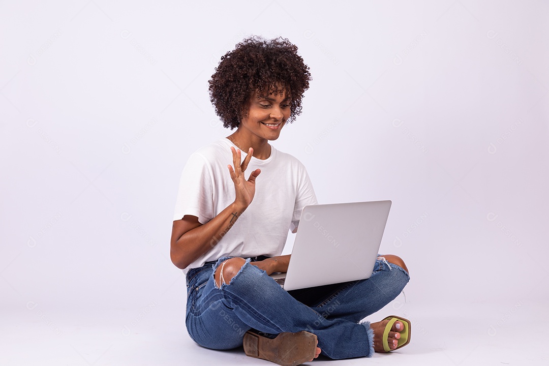 Linda mulher jovem garota com lindo cabelo afro mexendo em seu notebook