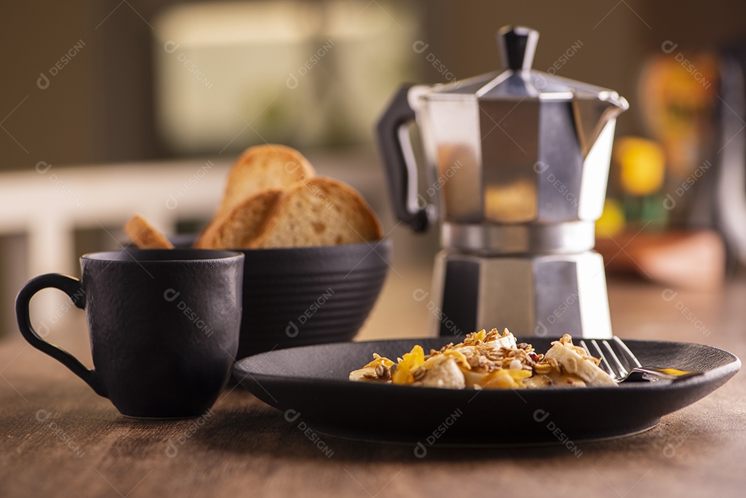 Prato com banana em rodelas com granola, frutas cristalizadas e mel