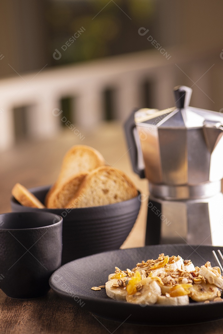 Prato com banana em rodelas com granola, frutas cristalizadas e mel