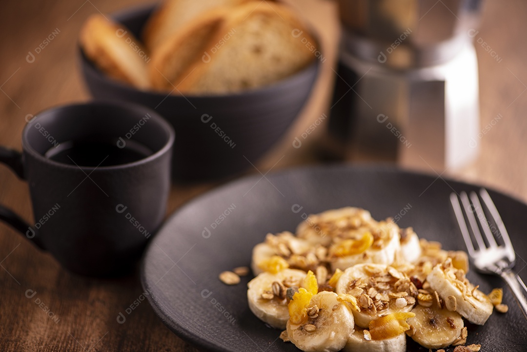 Prato com banana em rodelas com granola, frutas cristalizadas e mel