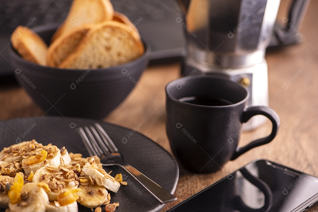 Prato com banana fatiada, granola, frutas cristalizadas e mel