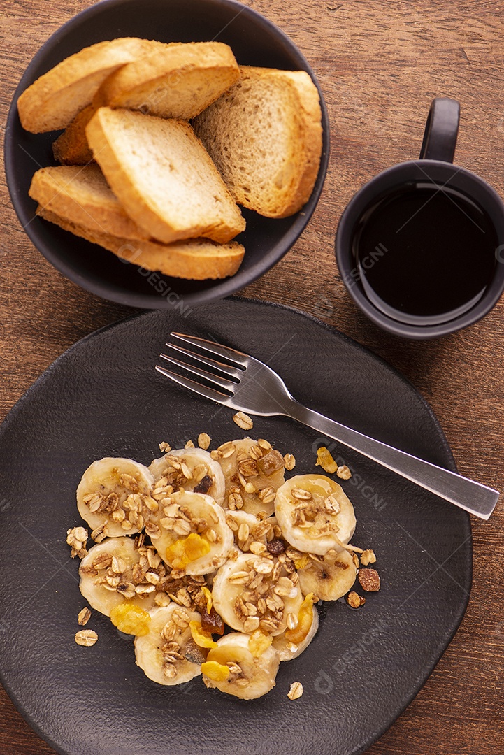 Prato com banana fatiada e granola com frutas secas