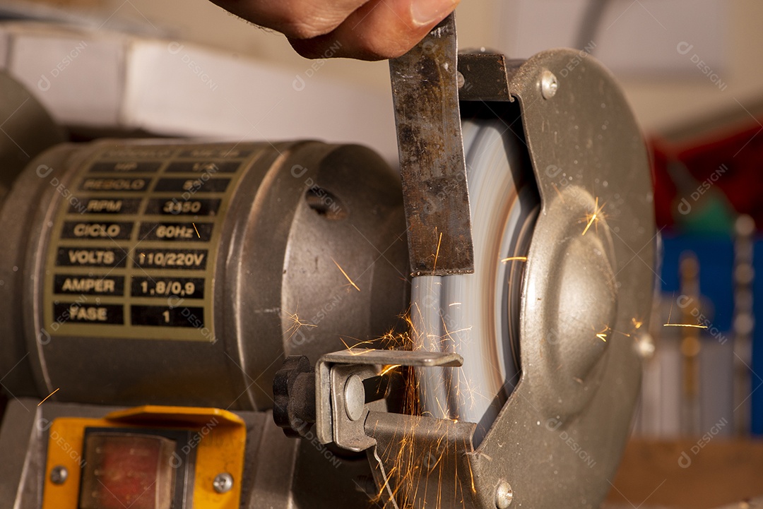 Luthier usando moedor para preparar peça de metal