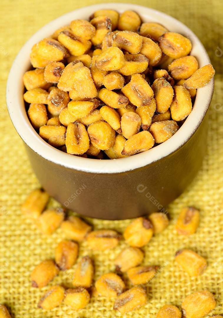 Milho torrado e salgado em pote de cerâmica sobre juta amarela