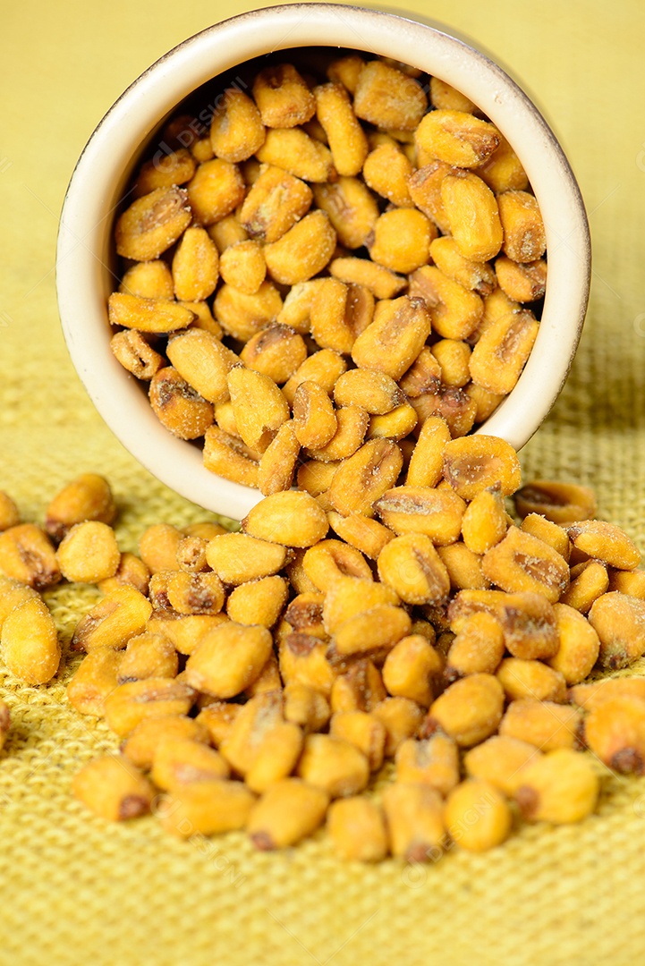 Milho torrado e salgado em pote de cerâmica sobre juta amarela