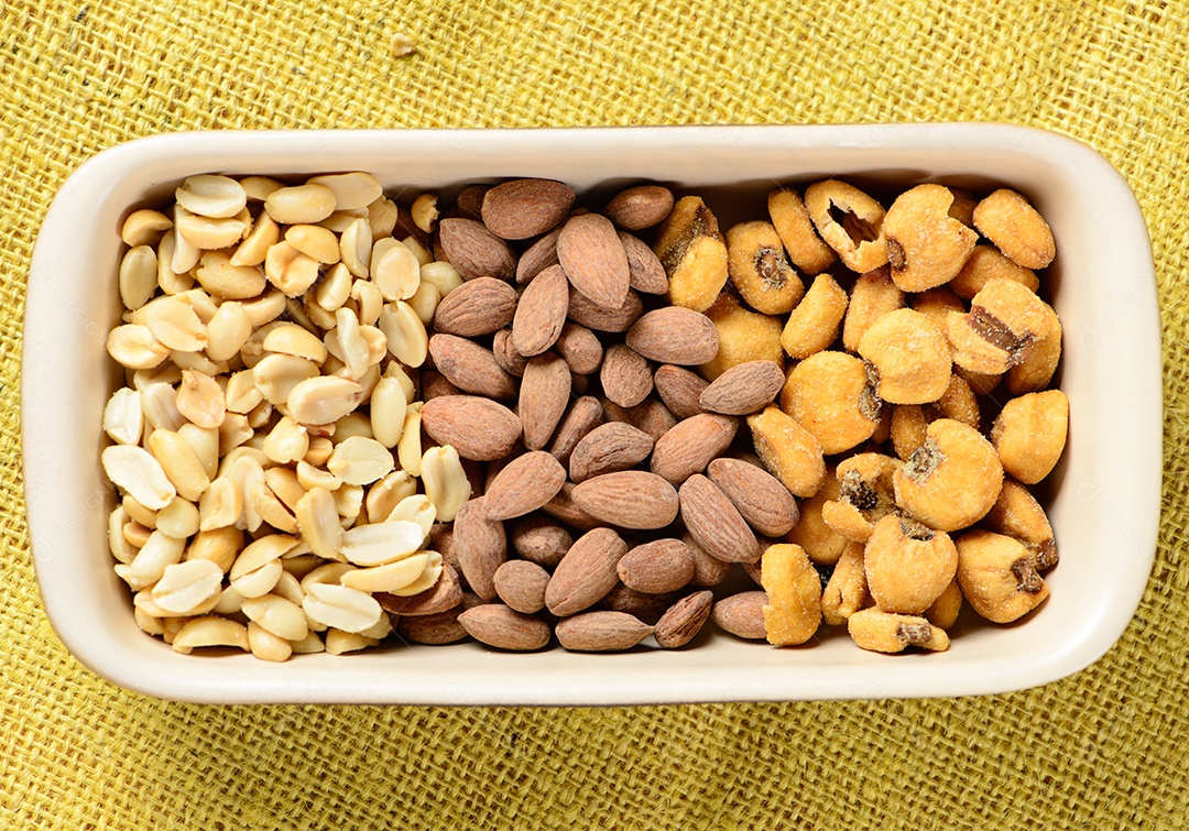 Amendoim torrado e salgado, nozes e milho em pote de cerâmica