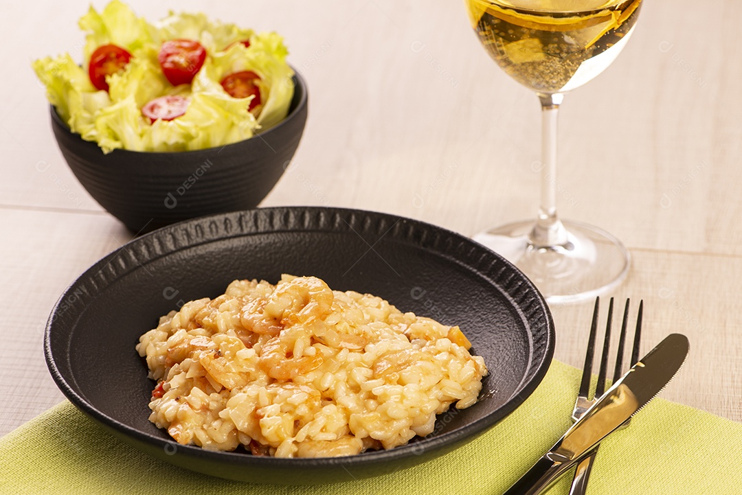Prato de risoto de camarão, salada de alface e tomate cereja