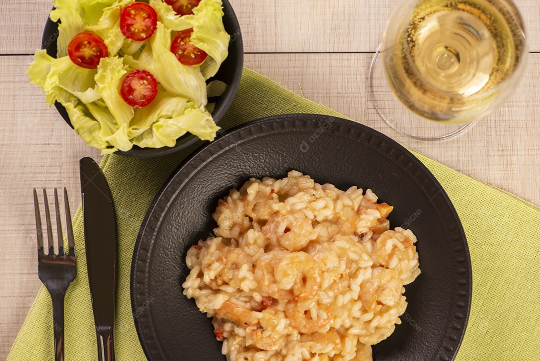 Prato de risoto de camarão, salada de alface e tomate cereja