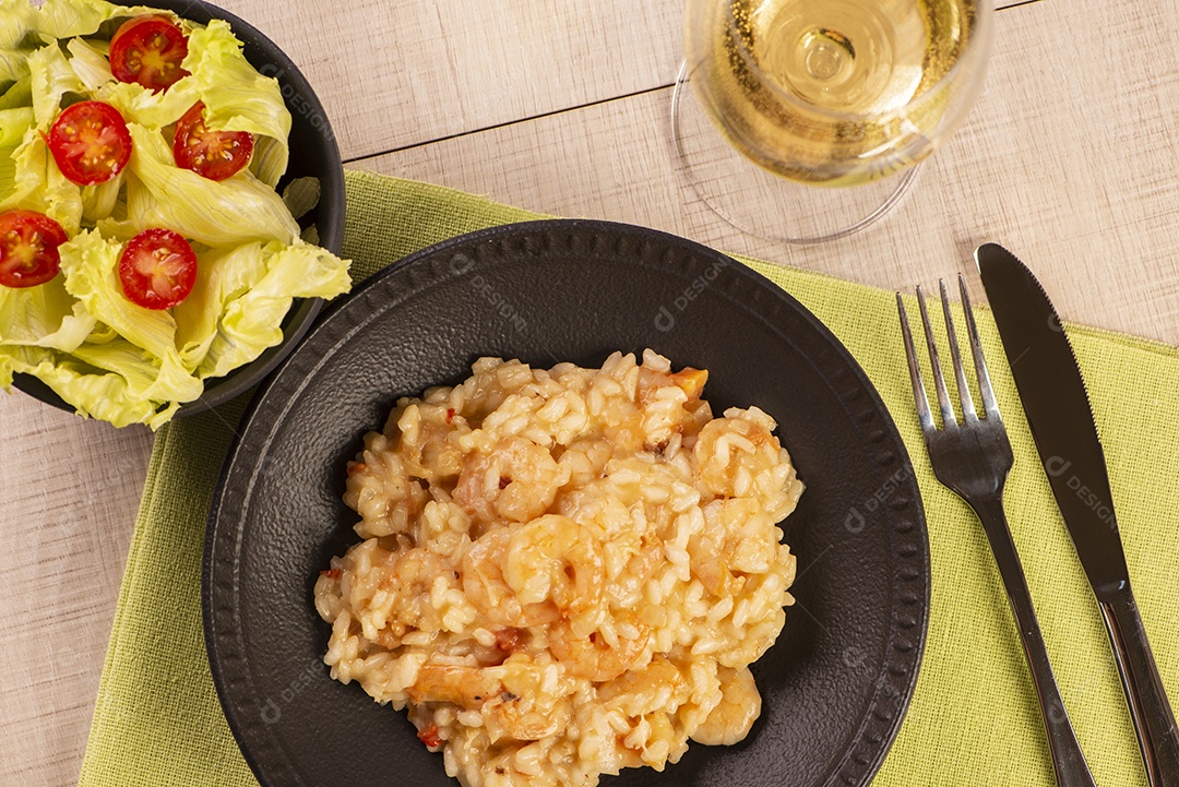 Prato de risoto de camarão, salada de alface e tomate cereja