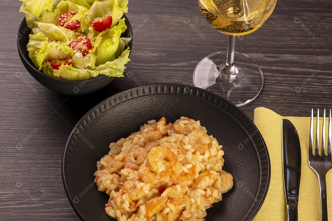 Prato de risoto de camarão, salada de alface e tomate cereja