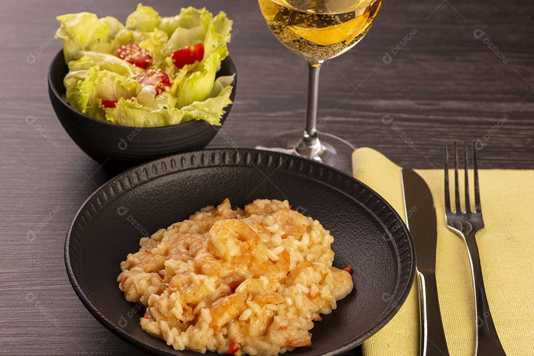 Prato de risoto de camarão, salada de alface e tomate cereja