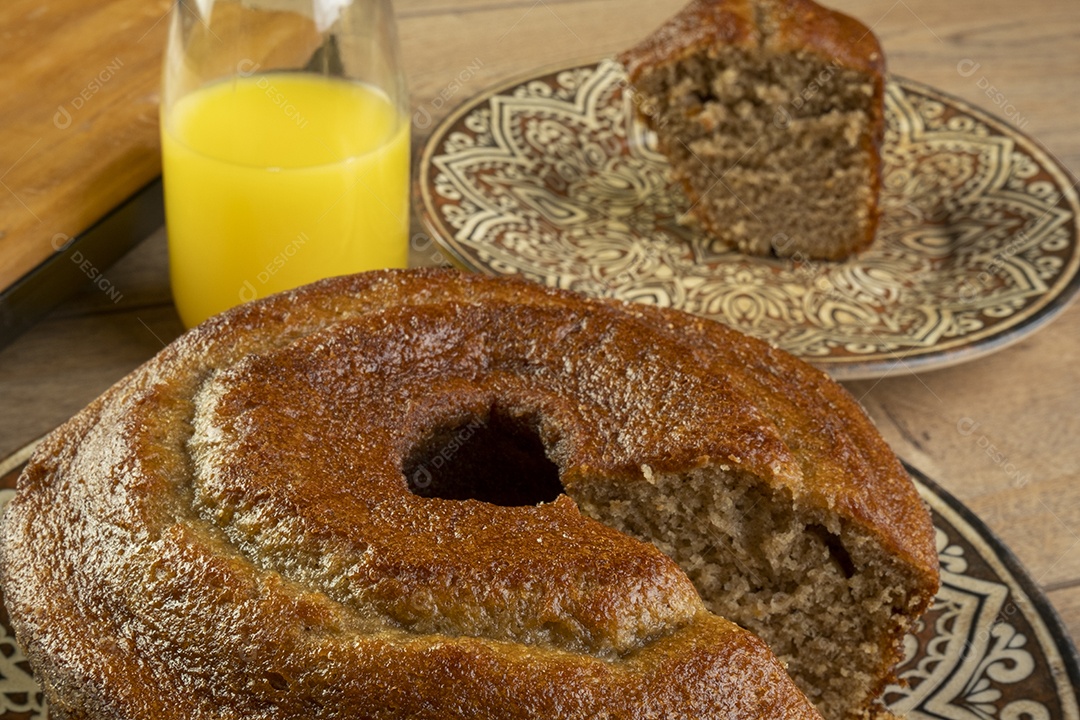 Bolo de banana e suco de laranja na mesa de madeira