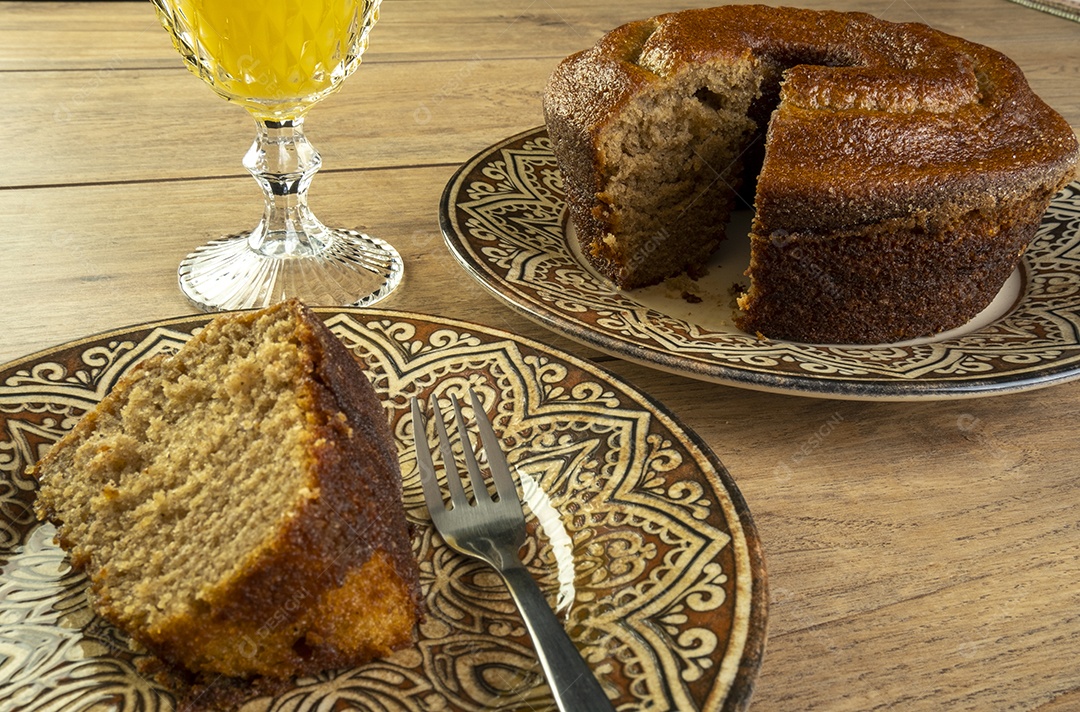 Bolo de banana e suco de laranja na mesa de madeira