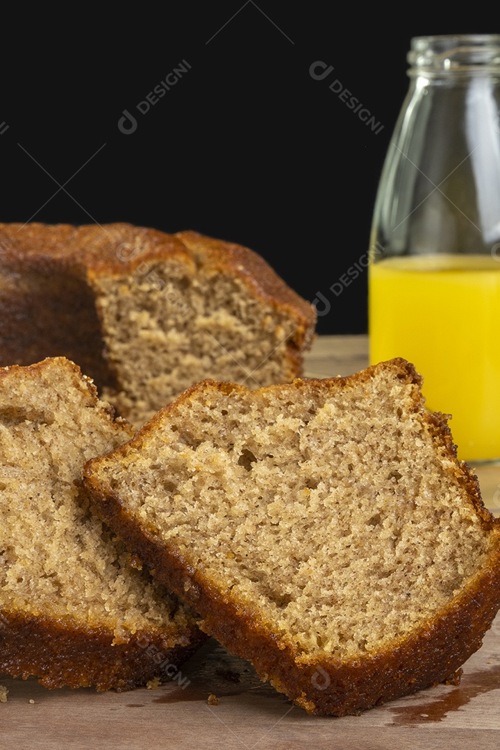 Bolo de banana e suco de laranja na mesa de madeira