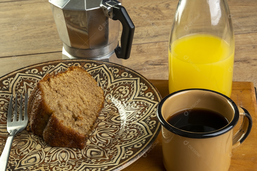 Algumas fatias de bolo de banana com uma xícara de café e suco de laranja