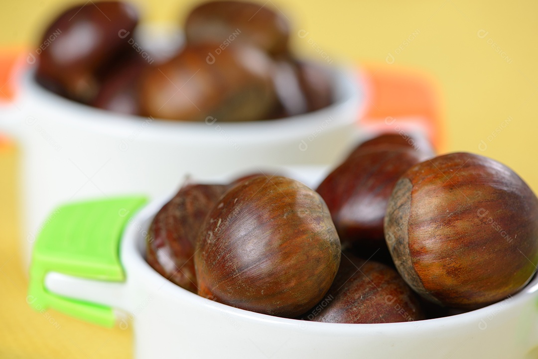 Nozes portuguesas em recipiente cerâmico sobre mesa com juta amarela