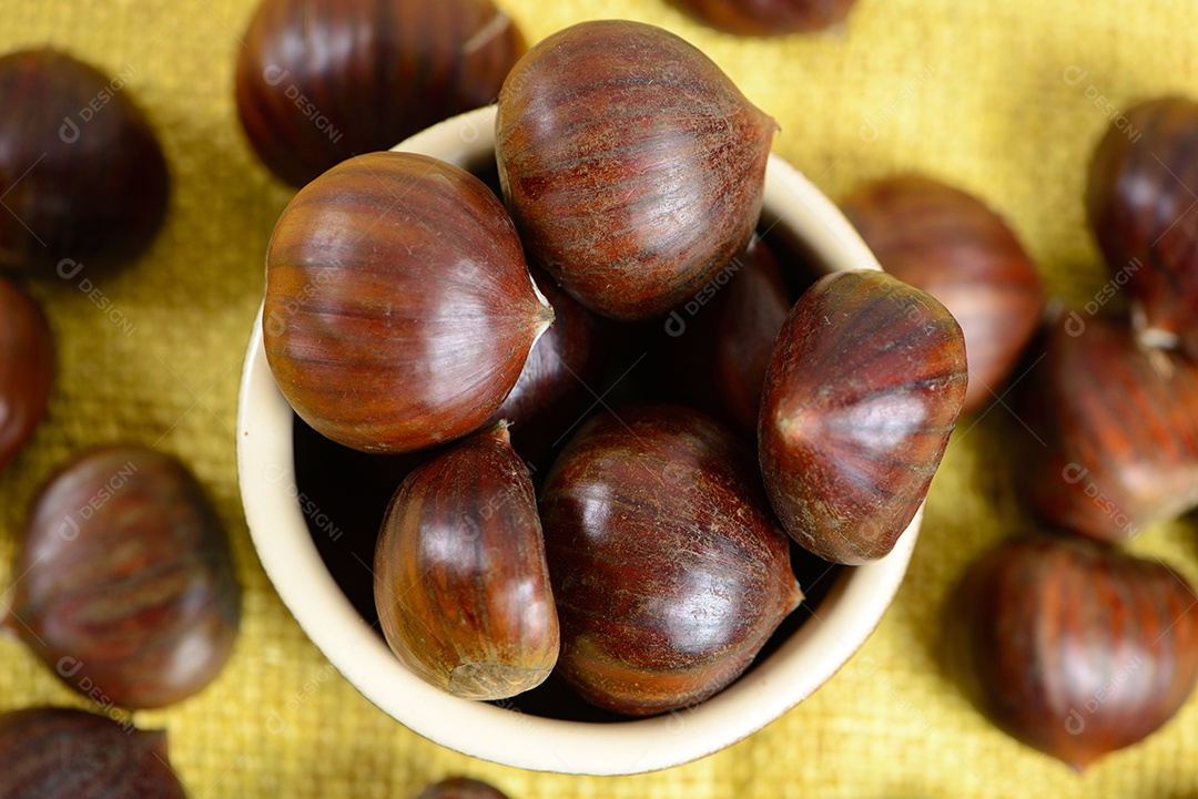 Nozes portuguesas em recipiente cerâmico sobre mesa com juta amarela