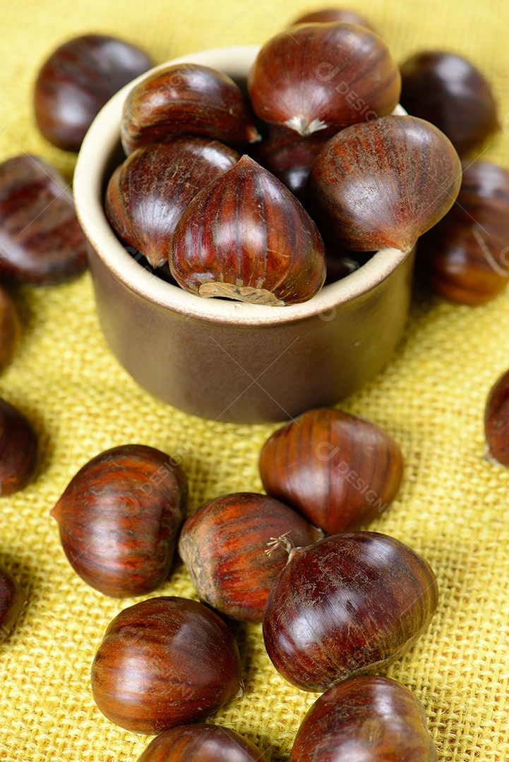Nozes portuguesas em recipiente cerâmico sobre mesa com juta amarela