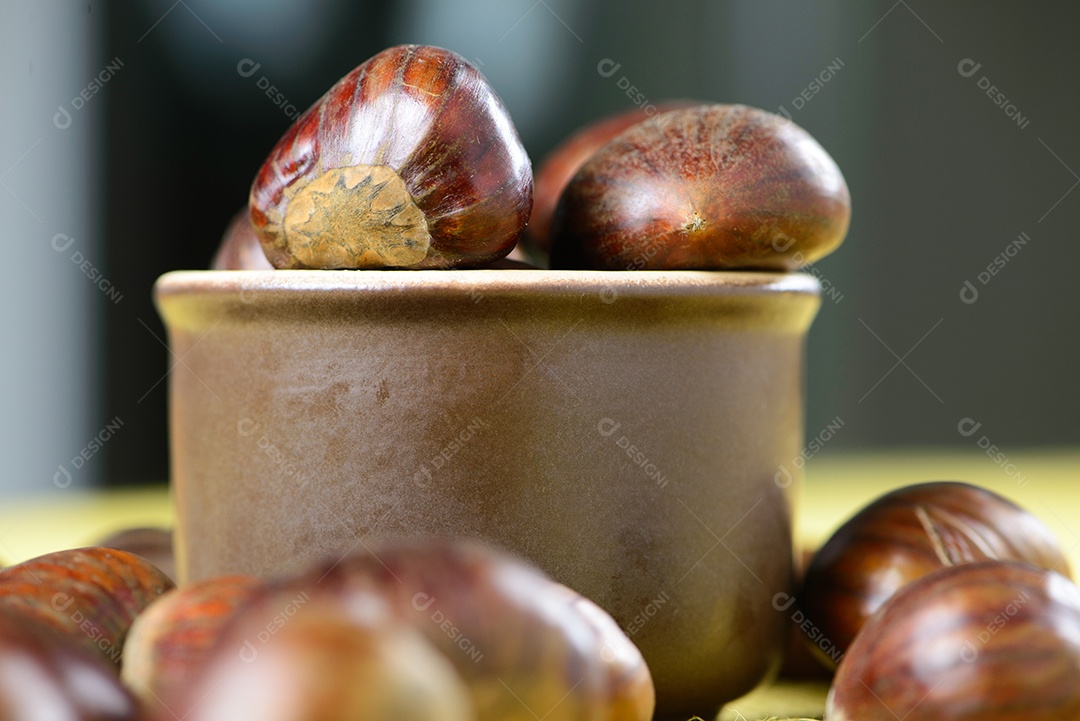 Nozes portuguesas em recipiente cerâmico sobre mesa com juta amarela