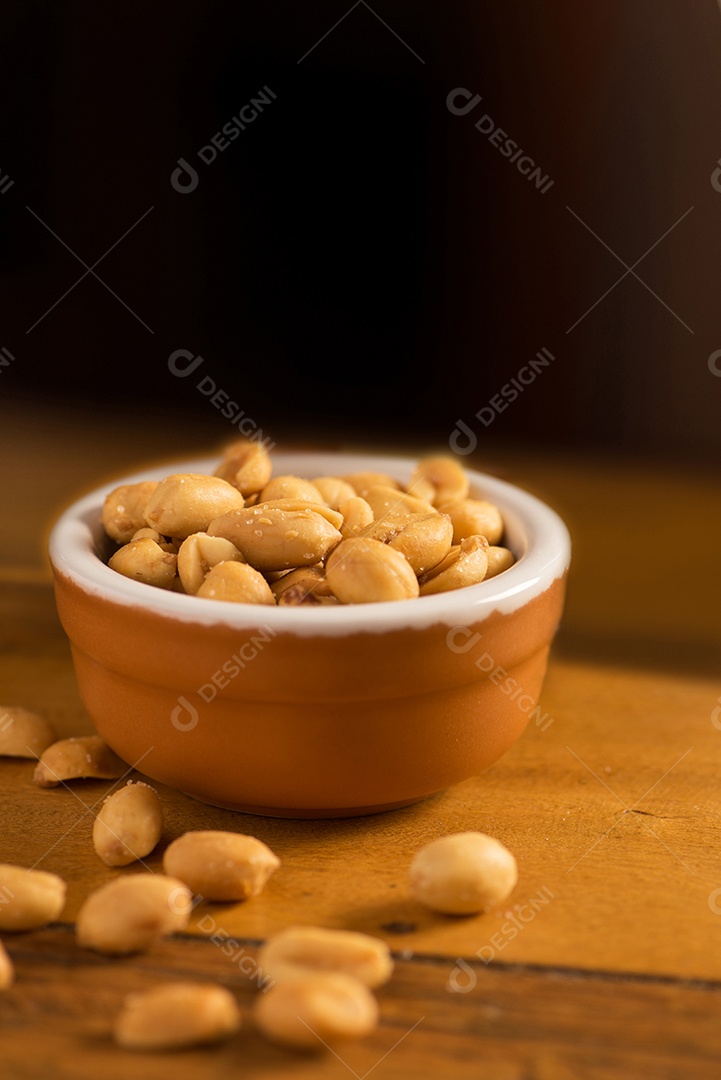 Amendoim torrado e salgado dobrado sobre mesa de madeira