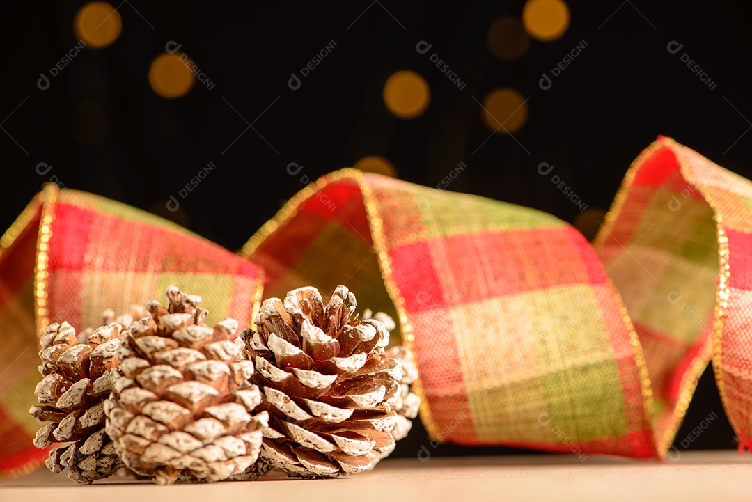 Pinhas com fita decorativa e fundo escuro com pequenos