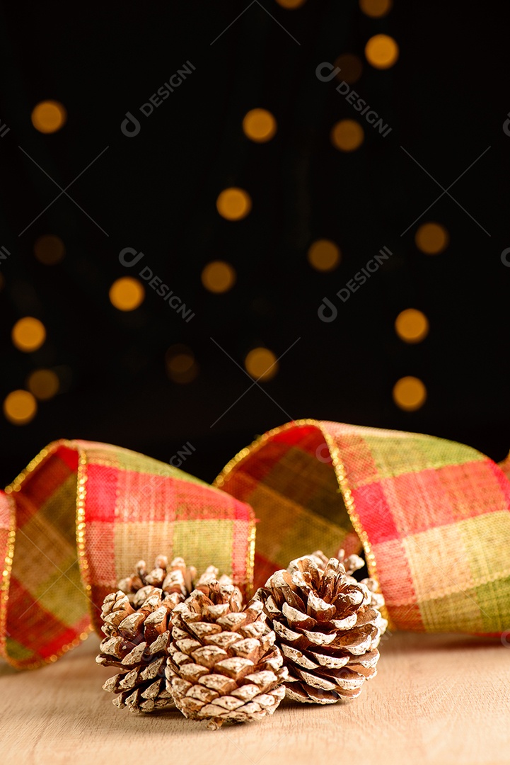 Pinhas com fita decorativa e fundo escuro com pequenos