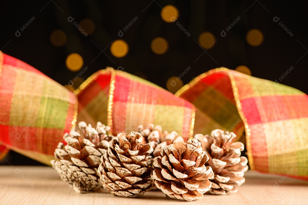 Pinhas com fita decorativa e fundo escuro com pequenos