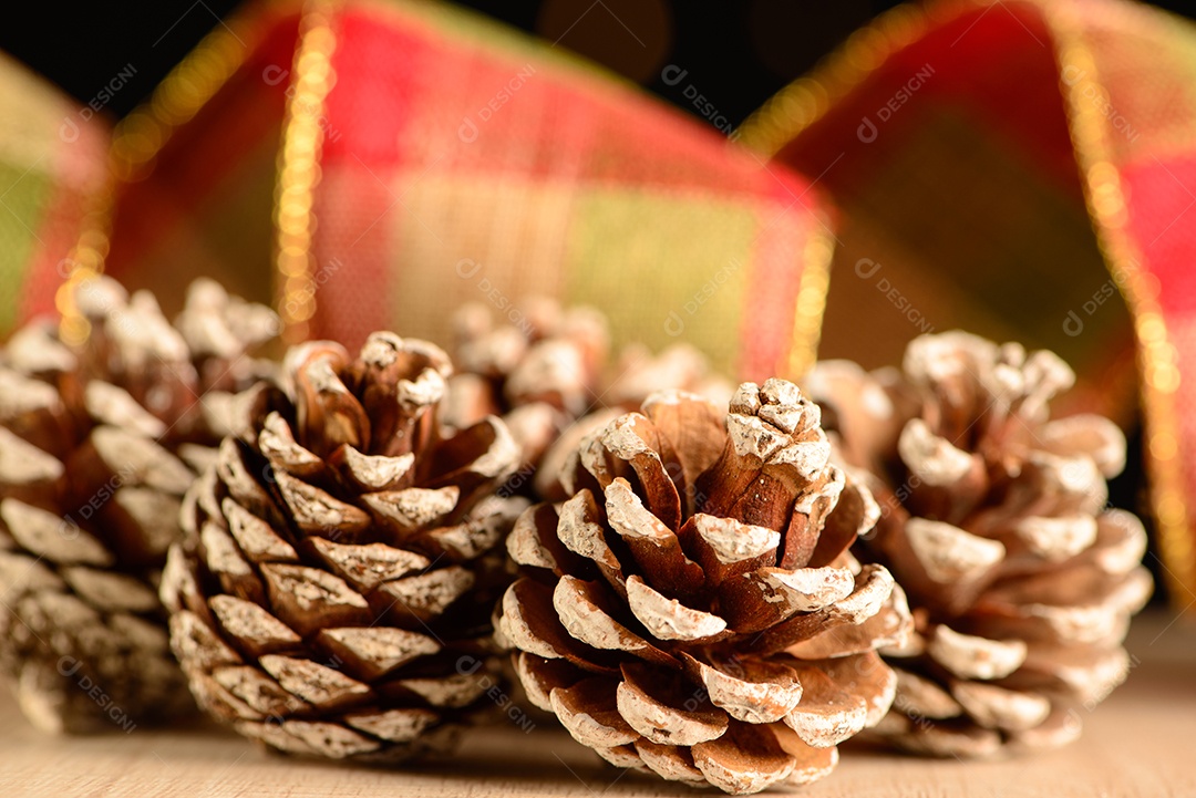 Pinhas com fita decorativa e fundo escuro com pequenos