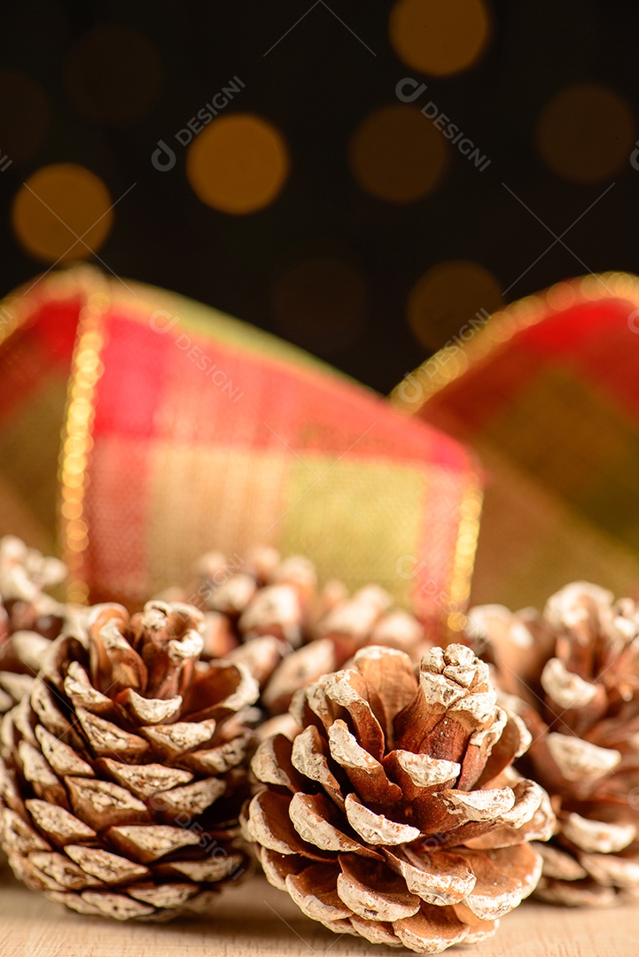 Pinhas com fita decorativa e fundo escuro com pequenos