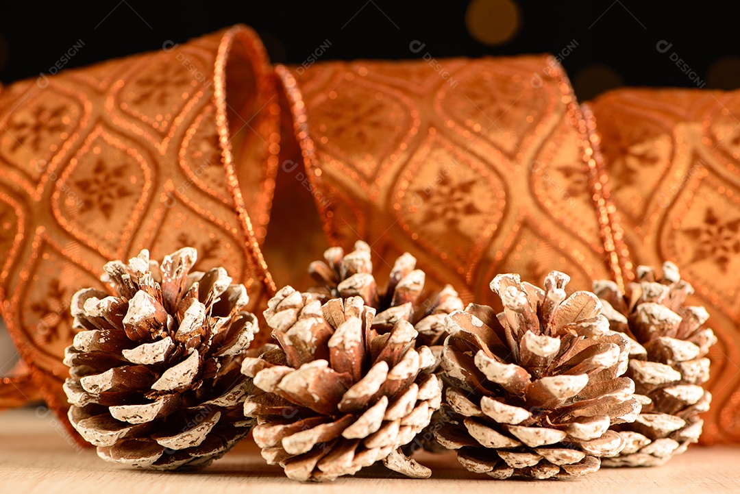 Pinhas com fita decorativa e fundo escuro com pequenos