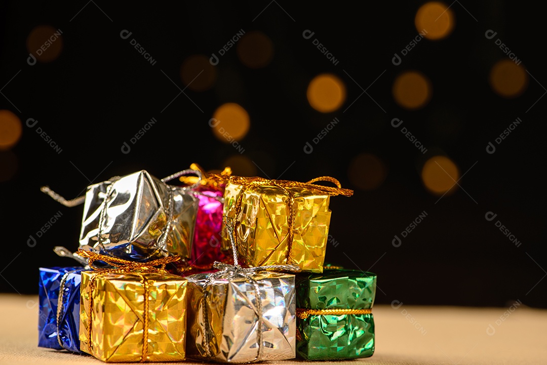 Pequenas caixas de presente em madeira com fundo escuro e pequenas luzes