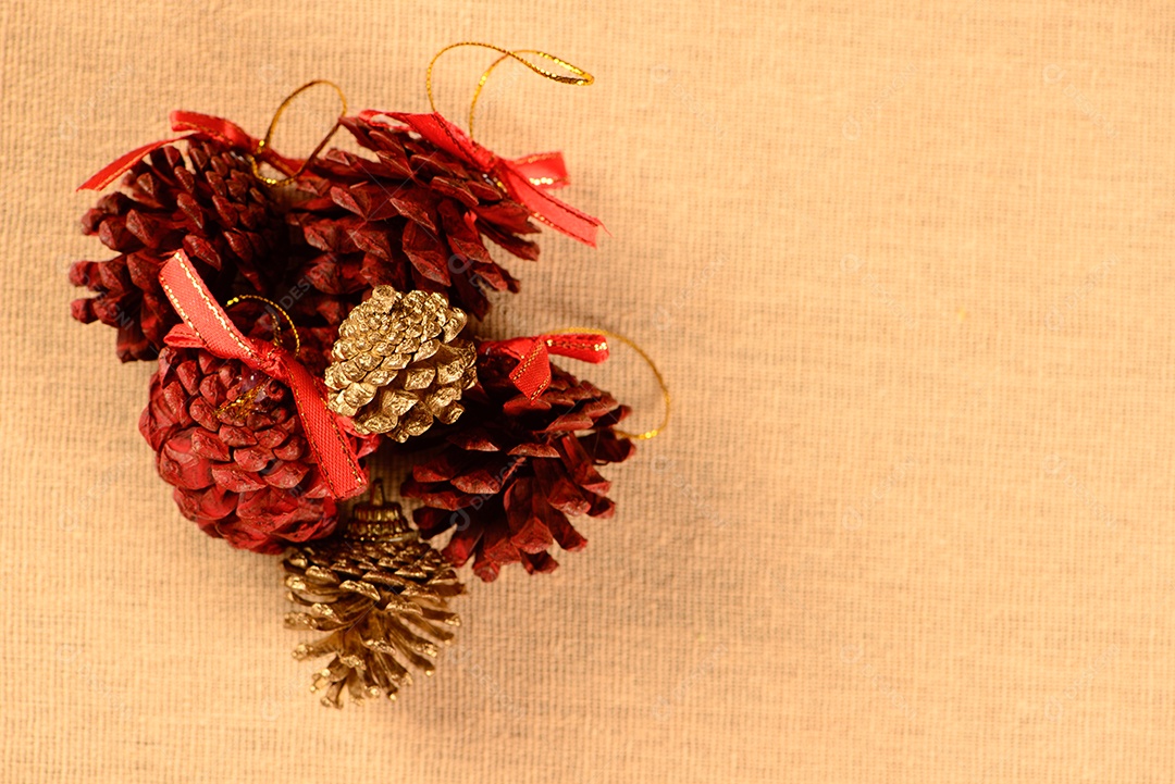 Pequenas pinhas vermelhas e douradas em tecido de algodão