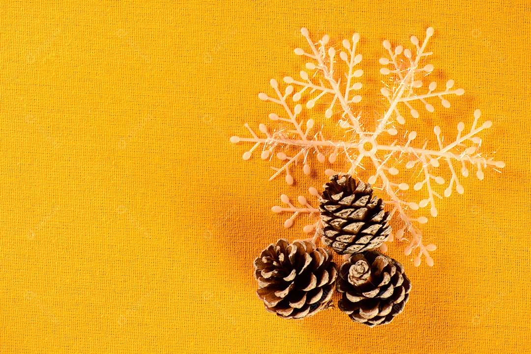 Pinhões e floco de neve decorativo em tecido amarelo