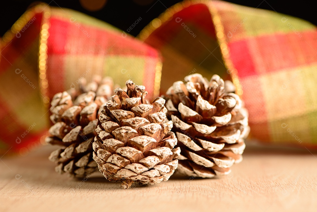Pinhas com fita decorativa e fundo escuro com pequenos