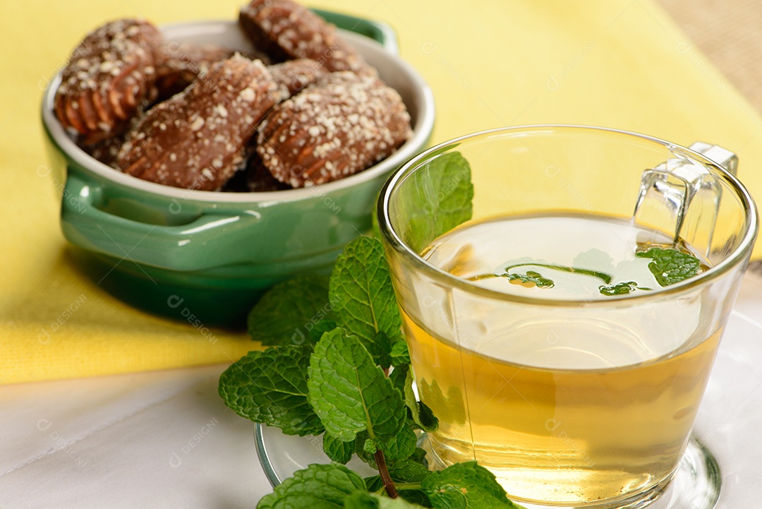 Chá de menta em copo transparente com biscoitos doces ao redor