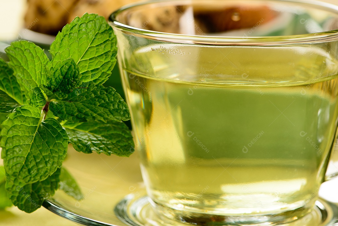 Chá de menta em copo transparente com biscoitos doces ao redor