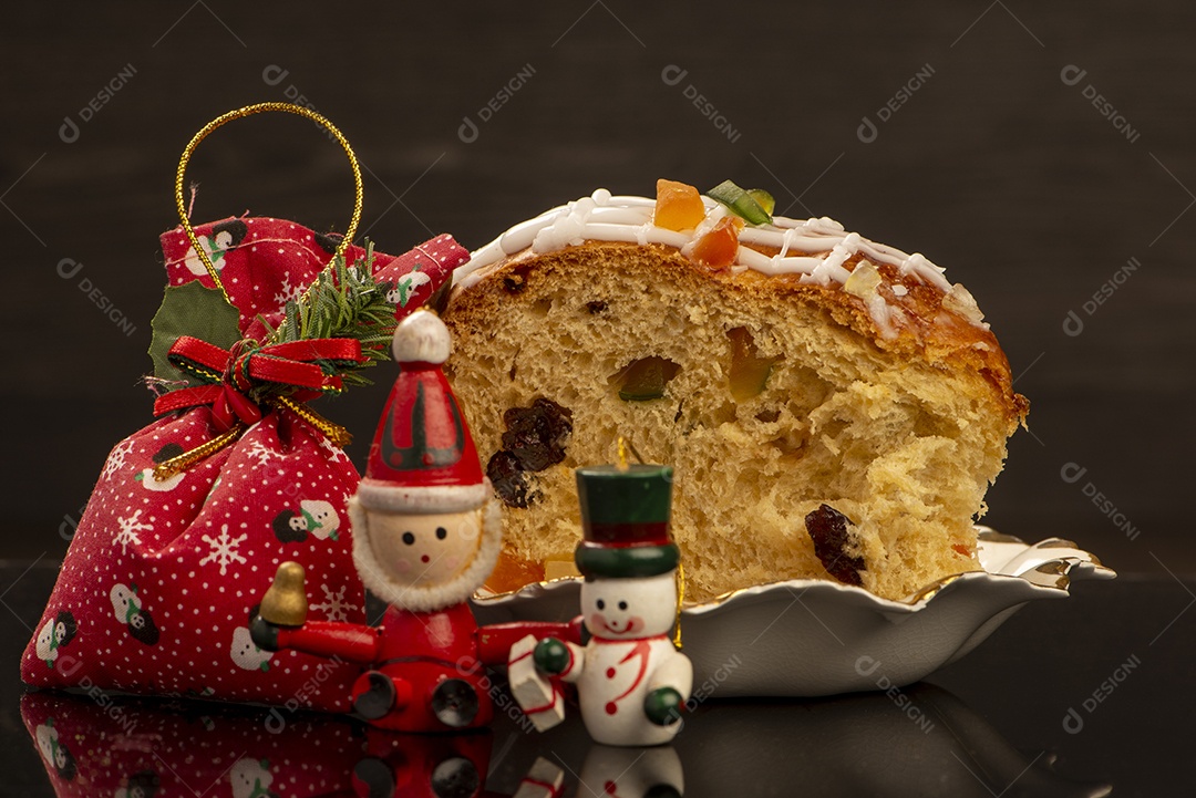 Uma fatia de panetone ao lado dos enfeites de natal