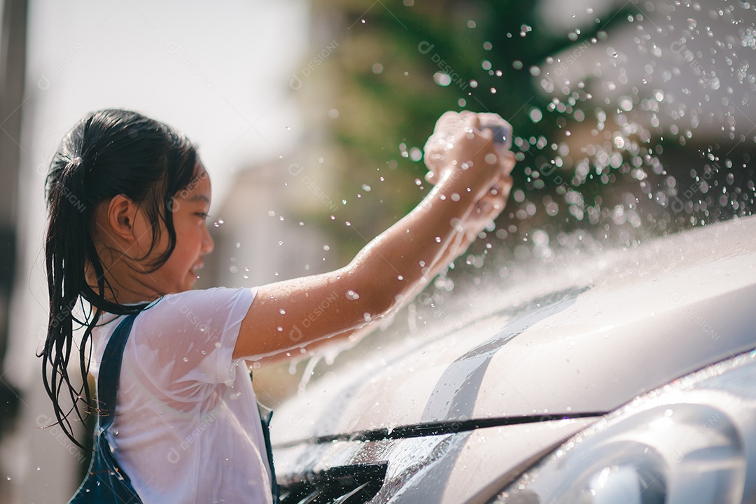 Irmãs asiáticas lavam seus carros e se divertem brincando dentro de casa em um dia quente de verão.