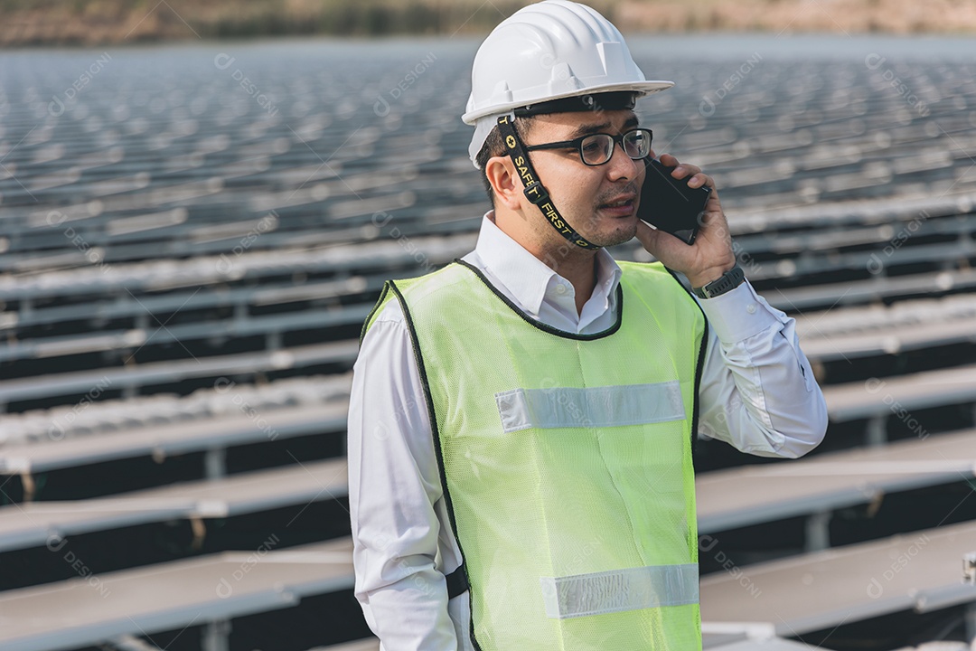 Homem profissional em placas fotovoltaicas com capacete de segurança