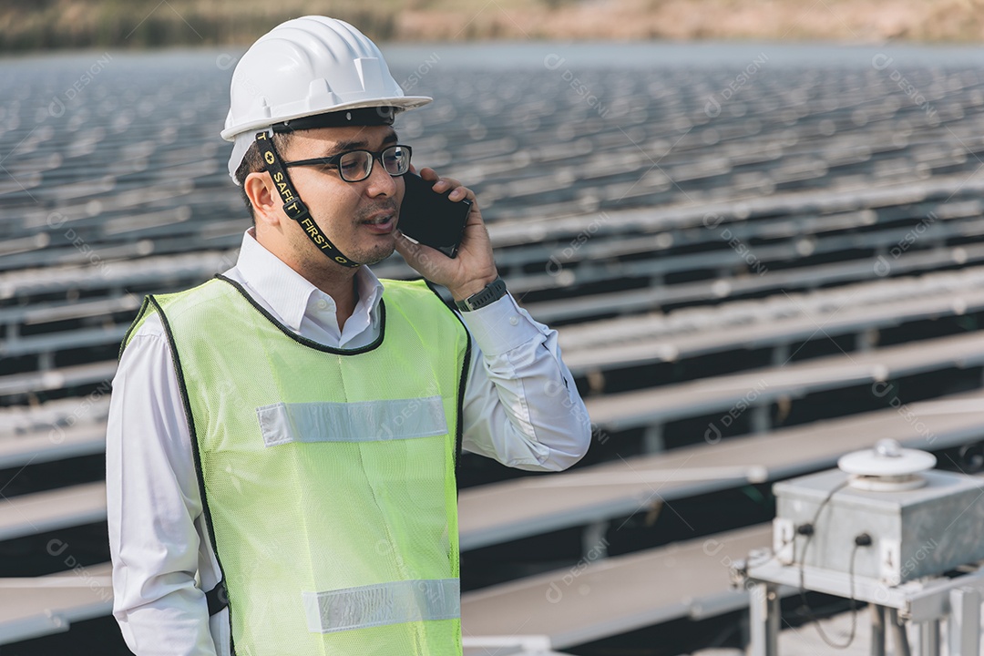 Homem profissional em placas fotovoltaicas com capacete de segurança