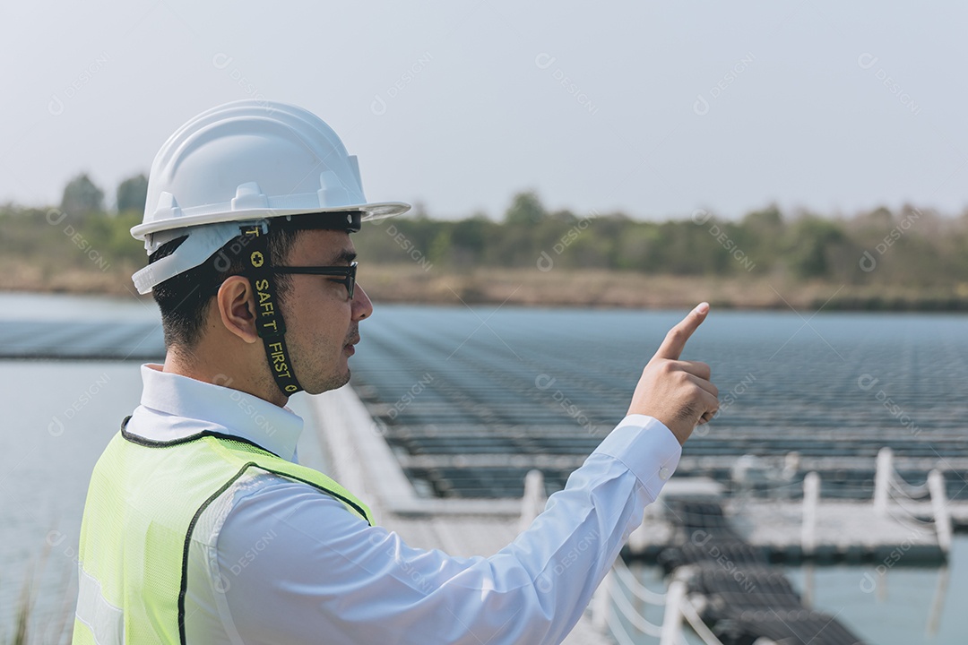Homem profissional em placas fotovoltaicas com capacete de segurança