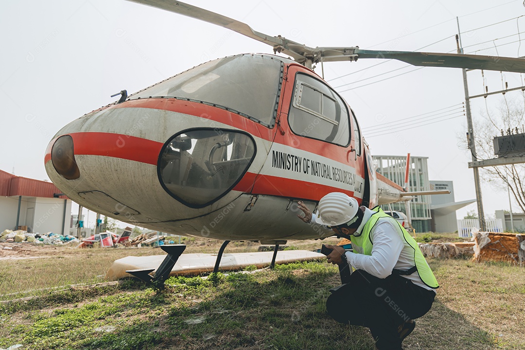 Engenheiro aeronáutico asiático trabalhando em helicóptero em hangar