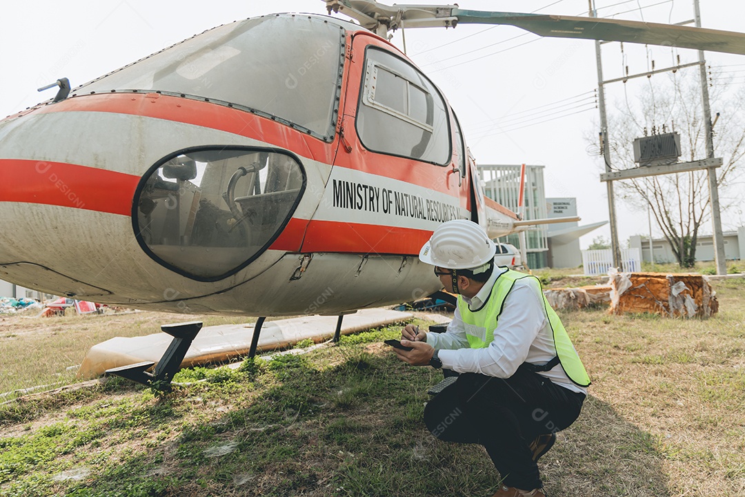 Engenheiro aeronáutico asiático trabalhando em helicóptero em hangar