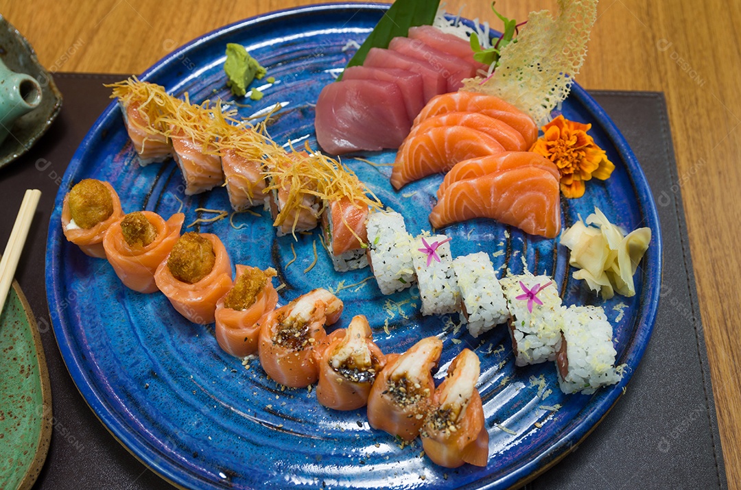 Combinado de diferentes sushis japoneses em um elegante prato azul.
