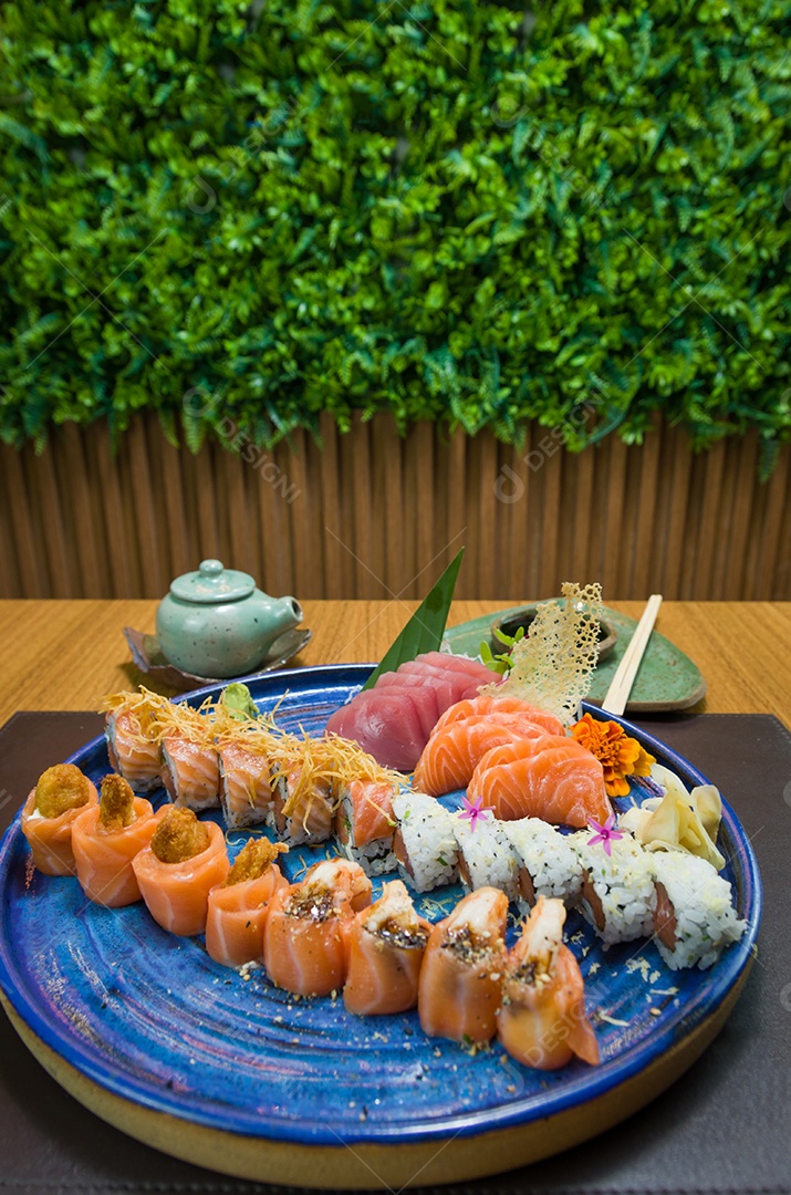 Combinado de diferentes sushis japoneses em um elegante prato azul.